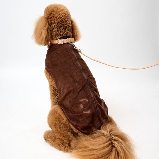 Poodle wearing a brown dog coat with a Snoot Style logo on a white background.