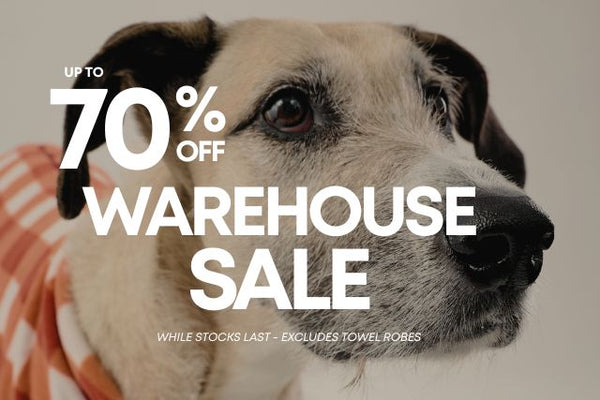 A close-up photo of a dog with large promotional text reading 'UP TO 70% OFF WAREHOUSE SALE' overlaid across the image.