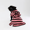 A French Bulldog wearing a pink and dark brown striped dog towel robe with a tie-back detail, photographed against a seamless white studio background.