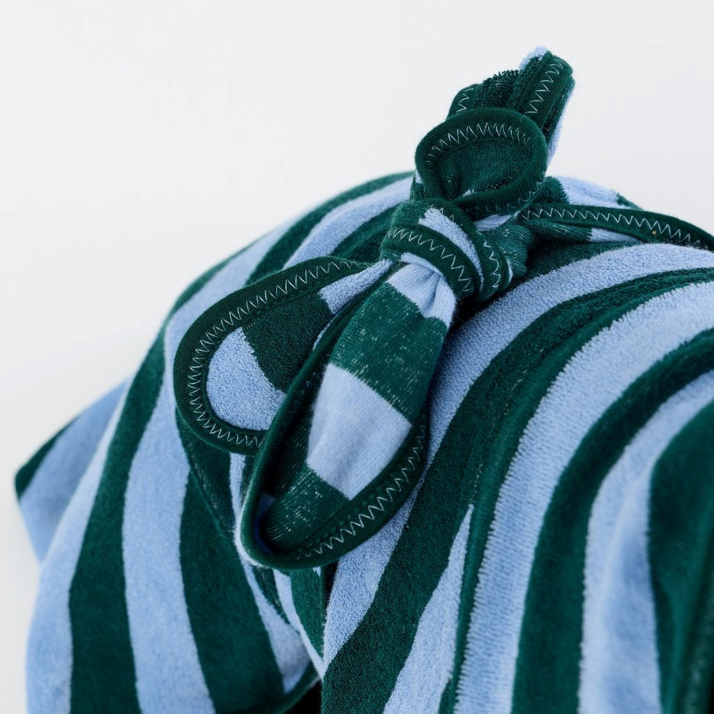 A close-up of a striped dog towel robe with a tie back on a white background.