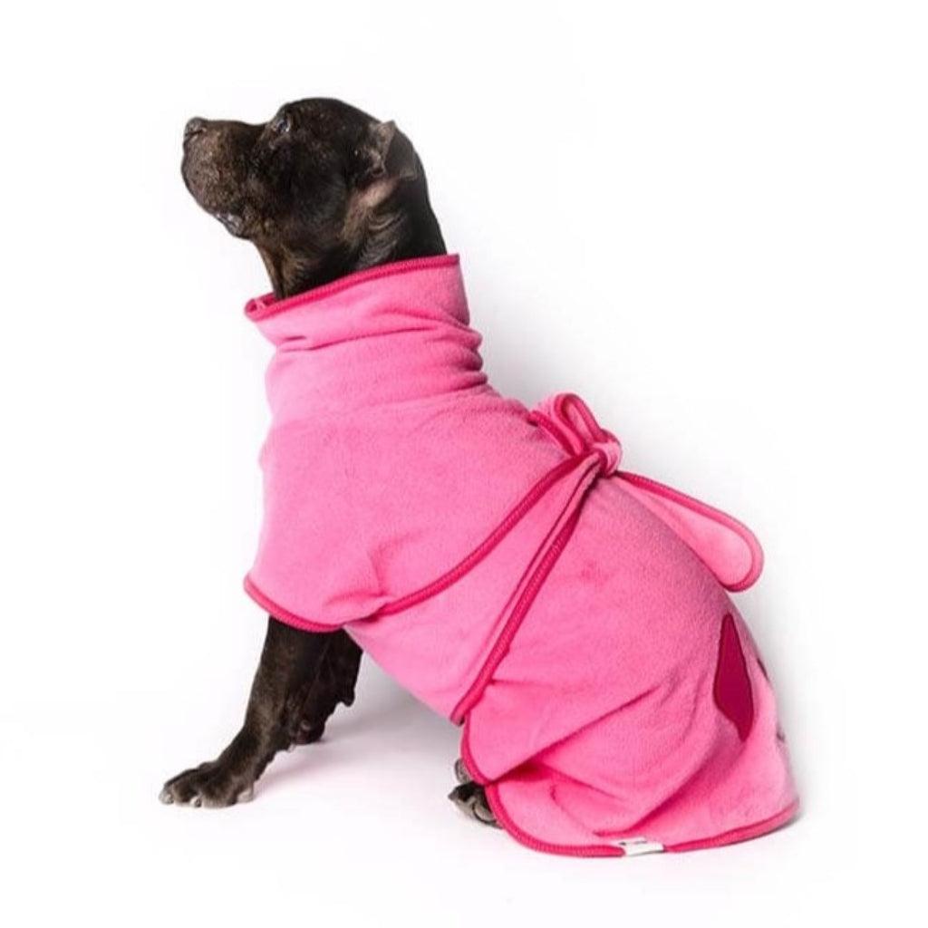 A Staffordshire Bull Terrier wearing a pink dog drying coat.