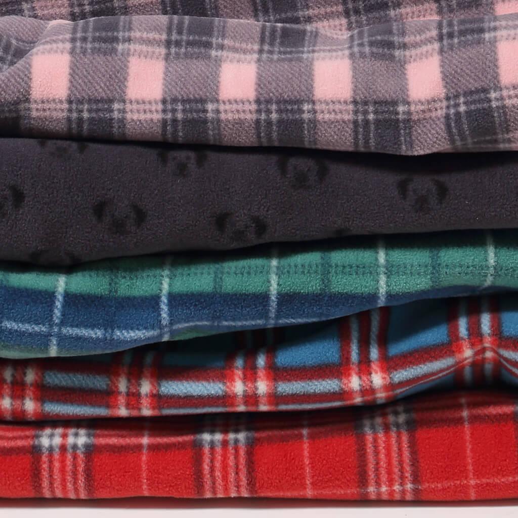 A folded stack of check dog blankets in 5 colours.